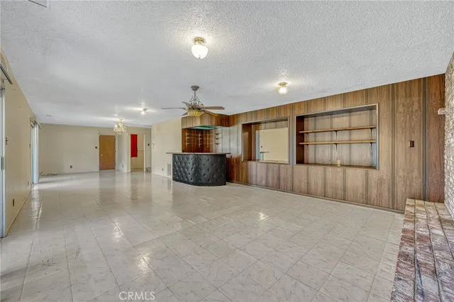 a view of an empty room with a window and fireplace