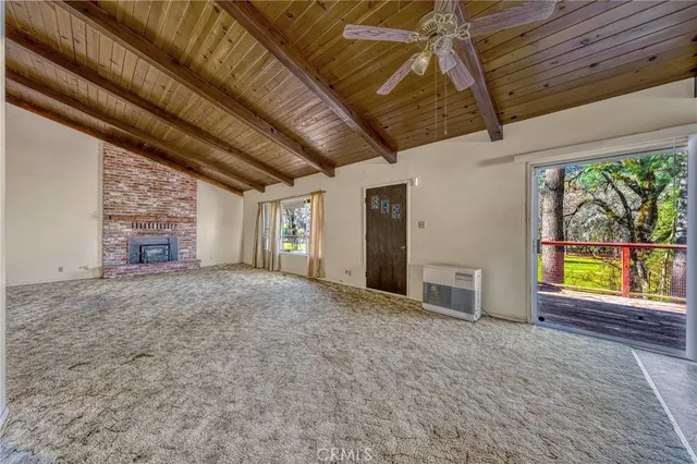 a view of an empty room with a fireplace and a window