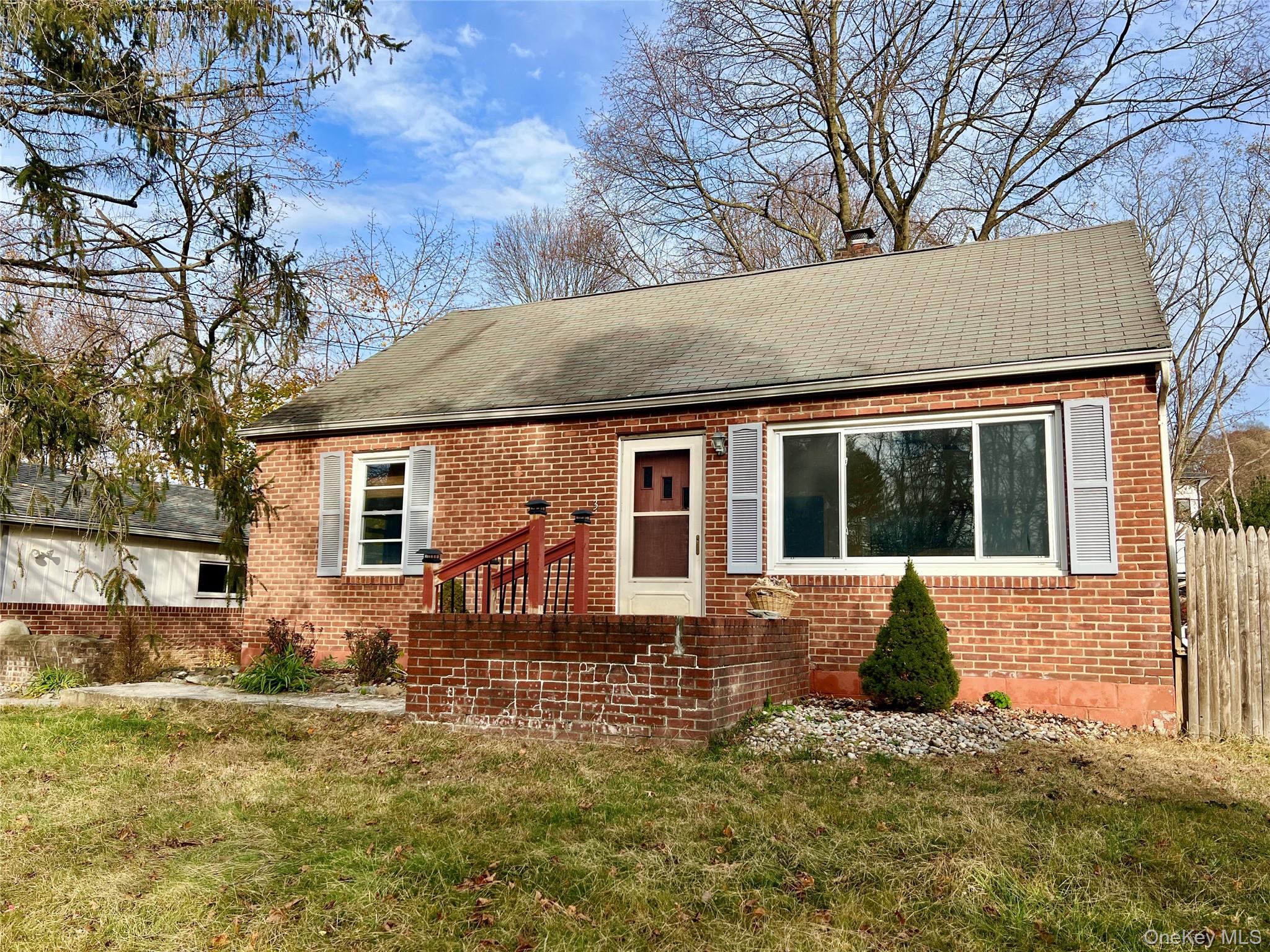 View of front of house with brick siding and roof with shingles