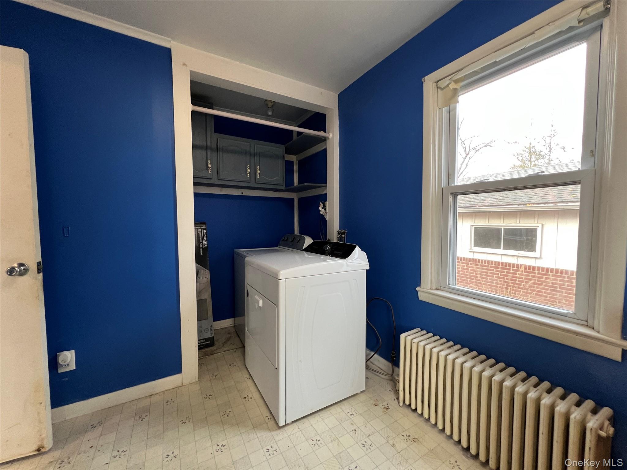 3 Davis Road Poughkeepsie, NY 12603 - Photo 23 of 34 Washroom with light floors, radiator heating unit, plenty of natural light, and washer and clothes dryer