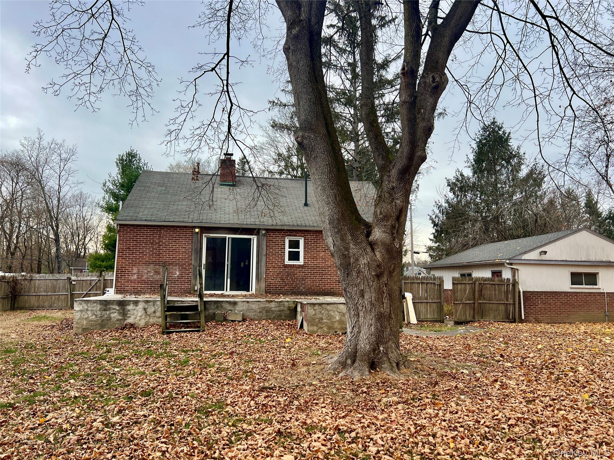3 Davis Road Poughkeepsie, NY 12603 - Photo 32 of 34 Back of property featuring brick siding, a chimney, and roof with shingles