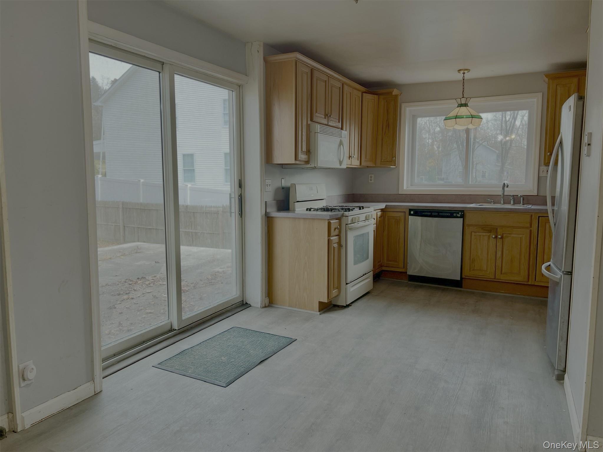 3 Davis Road Poughkeepsie, NY 12603 - Photo 8 of 34 Kitchen featuring appliances with stainless steel finishes, light brown cabinetry, decorative light fixtures, and light countertops