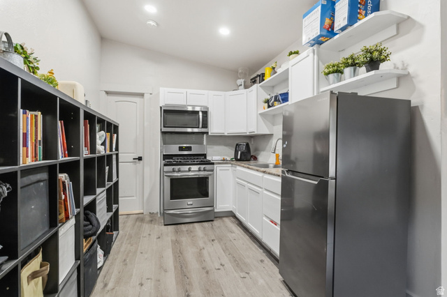 4270 River Road Oakley, UT 84055 - Photo 25 of 46 Kitchen featuring stainless steel appliances, white cabinetry, light-toned countertops, and wood-finish flooring