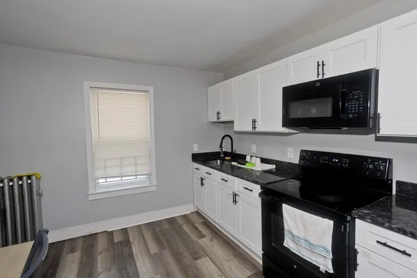 a kitchen with stainless steel appliances granite countertop a refrigerator a sink a stove a dining table and chairs