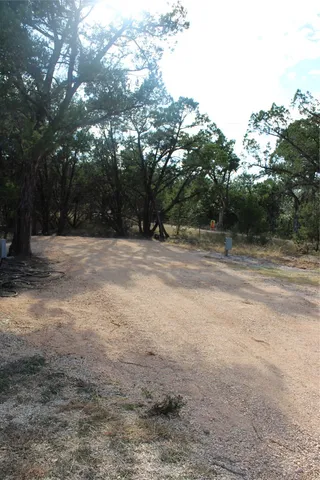 a backyard of a house with large trees and outdoor space