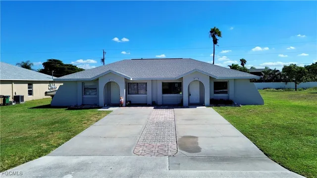 a front view of a house with a garden and yard