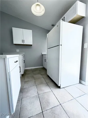 a view of a storage & utility room with a refrigerator