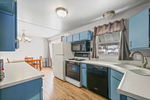 a kitchen with stainless steel appliances a sink cabinets and wooden floor