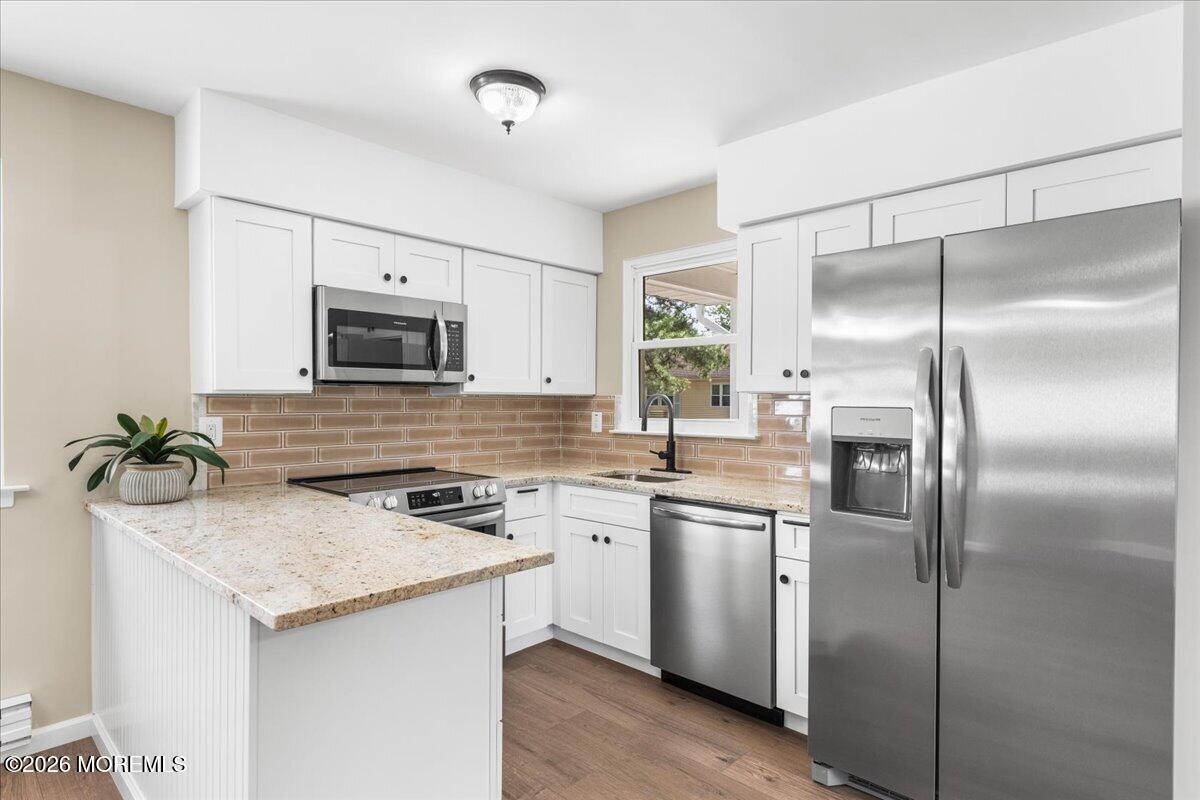 a kitchen with a sink stainless steel appliances and white cabinets