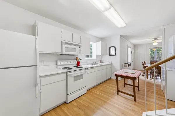 a kitchen with white cabinets and white appliances