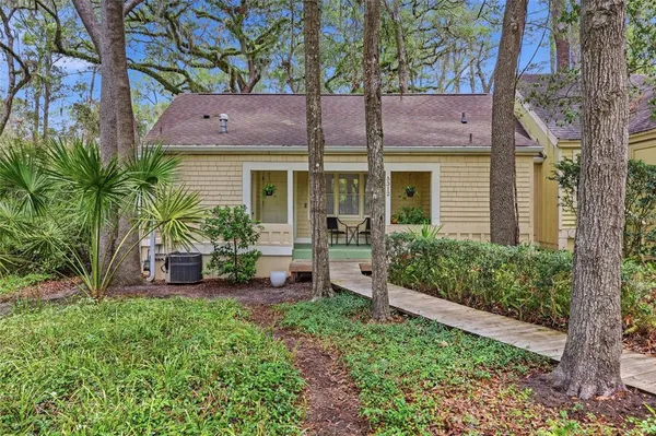 a front view of a house with a yard and potted plants