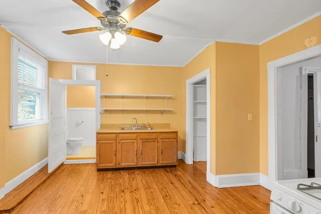 a view of a kitchen with wooden floor a sink and a window