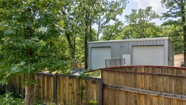 a view of backyard with wooden fence and large trees