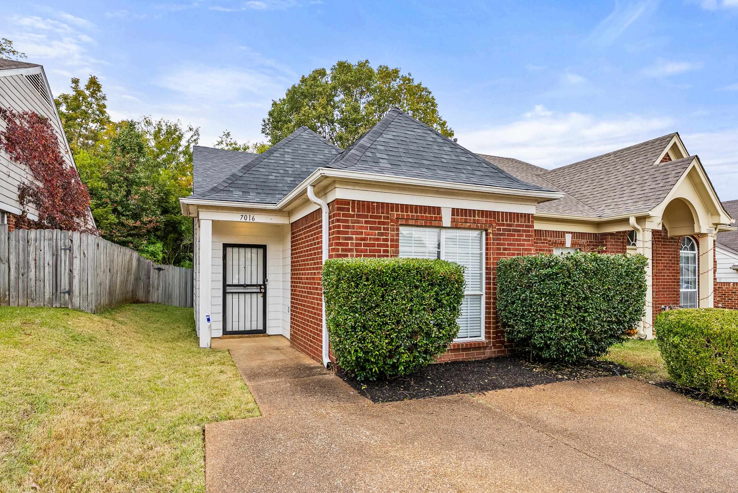 a view of a house with a large window and potted plants