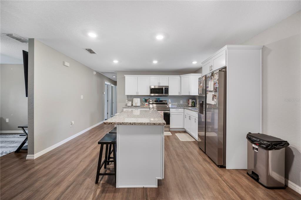 6830 County Line Road Lakeland, FL 33811 - Photo 12 of 32 a kitchen with stainless steel appliances granite countertop a refrigerator a stove top oven a sink dishwasher and wooden floor