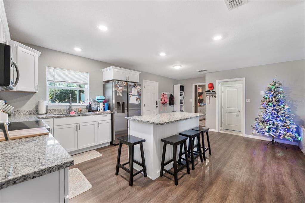 6830 County Line Road Lakeland, FL 33811 - Photo 13 of 32 a view of a dining room kitchen with furniture and wooden floor