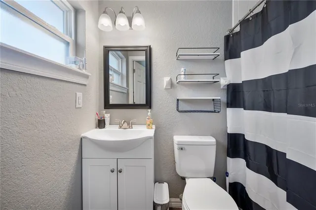a bathroom with a toilet a sink and mirror