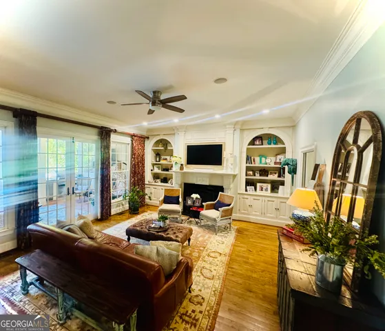 a living room with furniture a flat screen tv and a floor to ceiling window