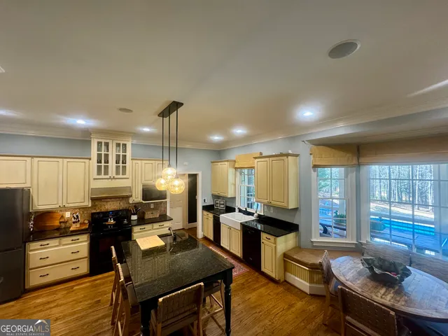 a living room with furniture kitchen view and a wooden floor
