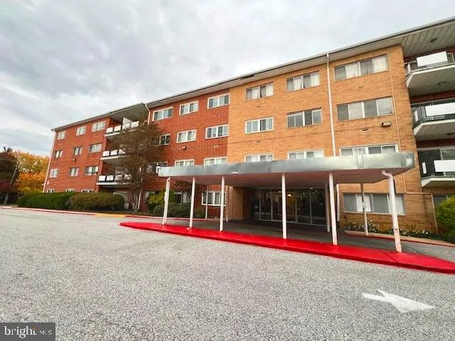 a multi story building with sign board and yard