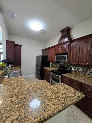 a kitchen with stainless steel appliances granite countertop a sink stove and refrigerator