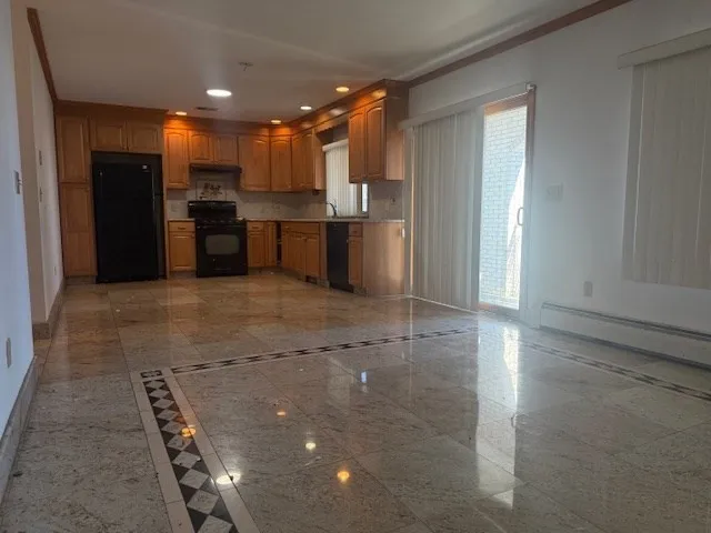 a view of a kitchen with kitchen island a sink stainless steel appliances and cabinets