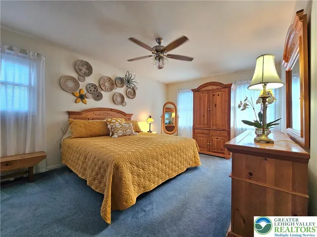 a bedroom with a bed and dresser with racks on the wall