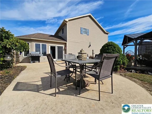 a view of a house with backyard and sitting area