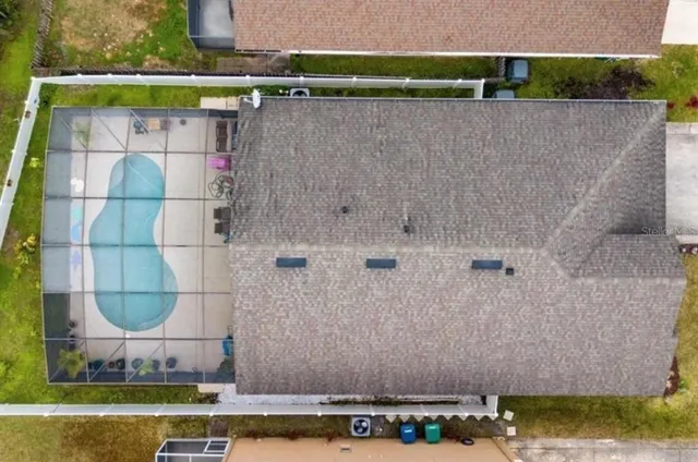 an aerial view of a house with a yard and large trees