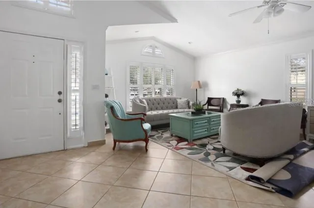 a living room with furniture a large window and a dining table