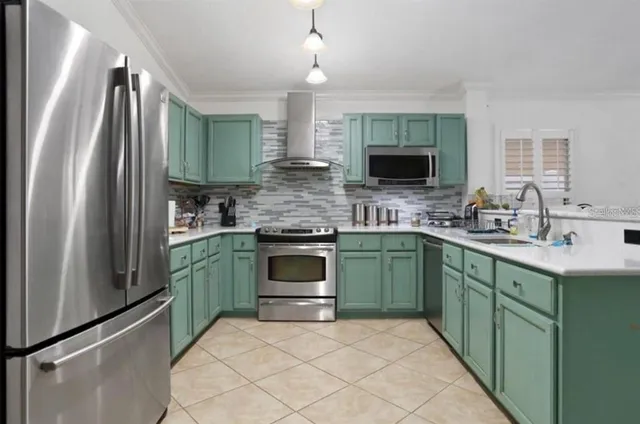 a kitchen with stainless steel appliances kitchen island granite countertop a sink and a refrigerator