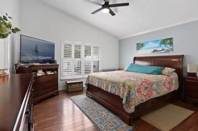 a bedroom with a bed dresser and a flat tv screen