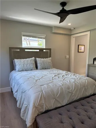 a bedroom with a bed and a lamp on the dresser