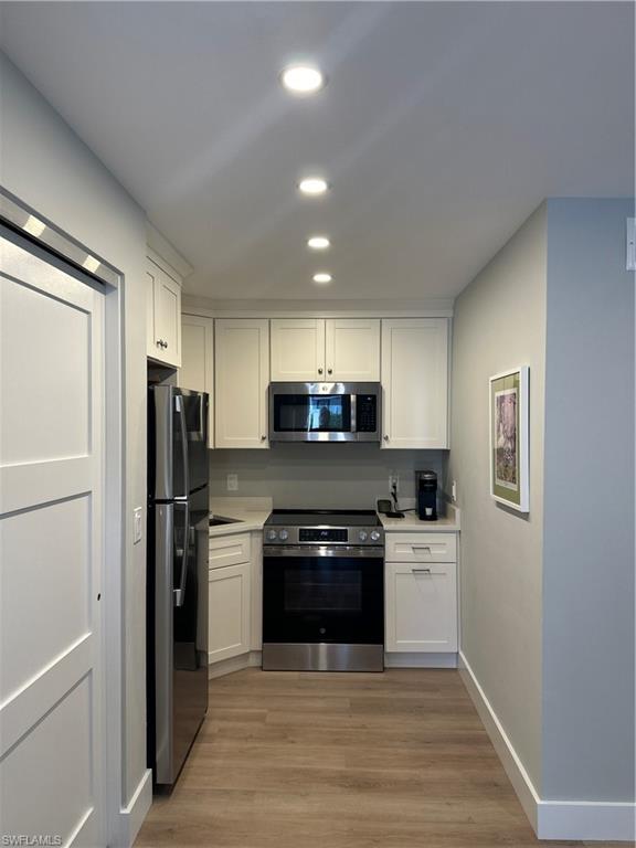 780 10th Avenue South, Unit 5 Naples, FL 34102 - Photo 3 of 27 a kitchen with a stove a refrigerator and a sink