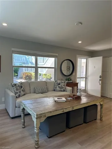 a living room with stainless steel appliances granite countertop furniture and a large window