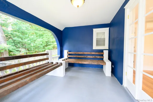 a view of wooden floor with a window and a kitchen view