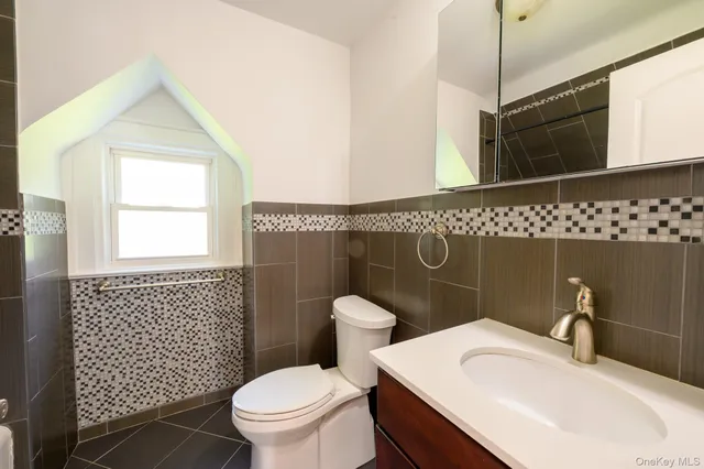 a bathroom with a sink a toilet a mirror and shower