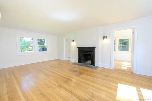 a view of empty room with wooden floor and fireplace