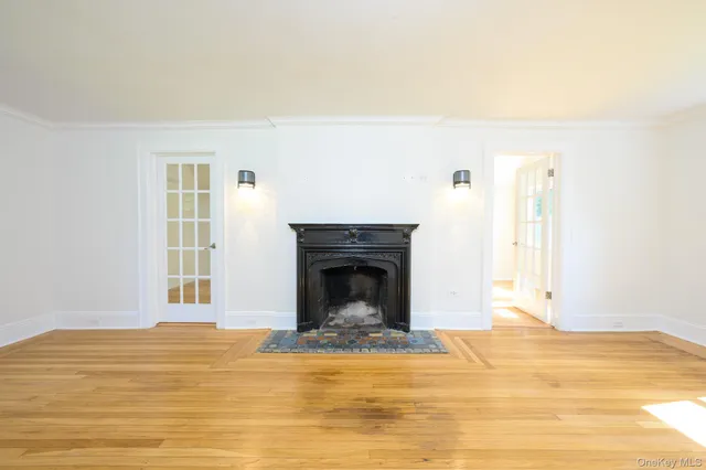 a view of a livingroom with a fireplace a ceiling fan and front door