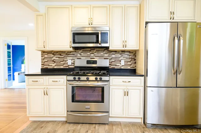 a kitchen with a stove a refrigerator and a microwave