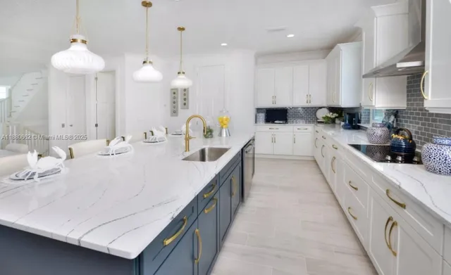 a large white kitchen with lots of counter space and stainless steel appliances