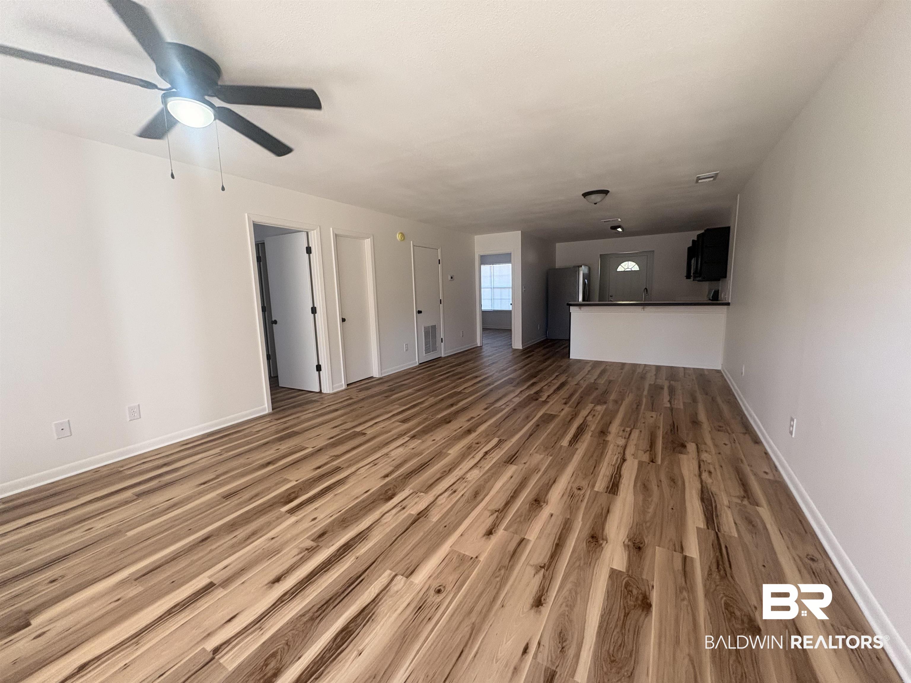 109-111 North Beech Street, Unit A & B Foley, AL 36535 - Photo 11 of 16 Unfurnished living room featuring dark wood-style flooring and a ceiling fan