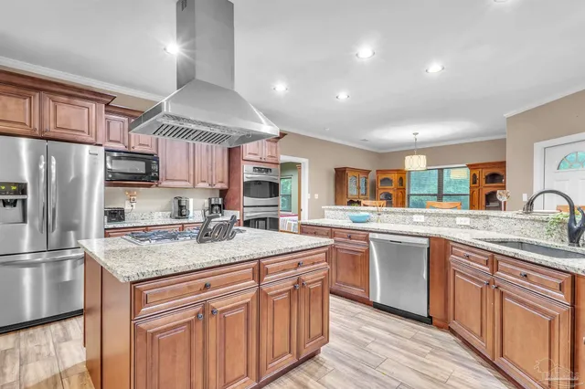 a kitchen with stainless steel appliances granite countertop a sink stove and refrigerator