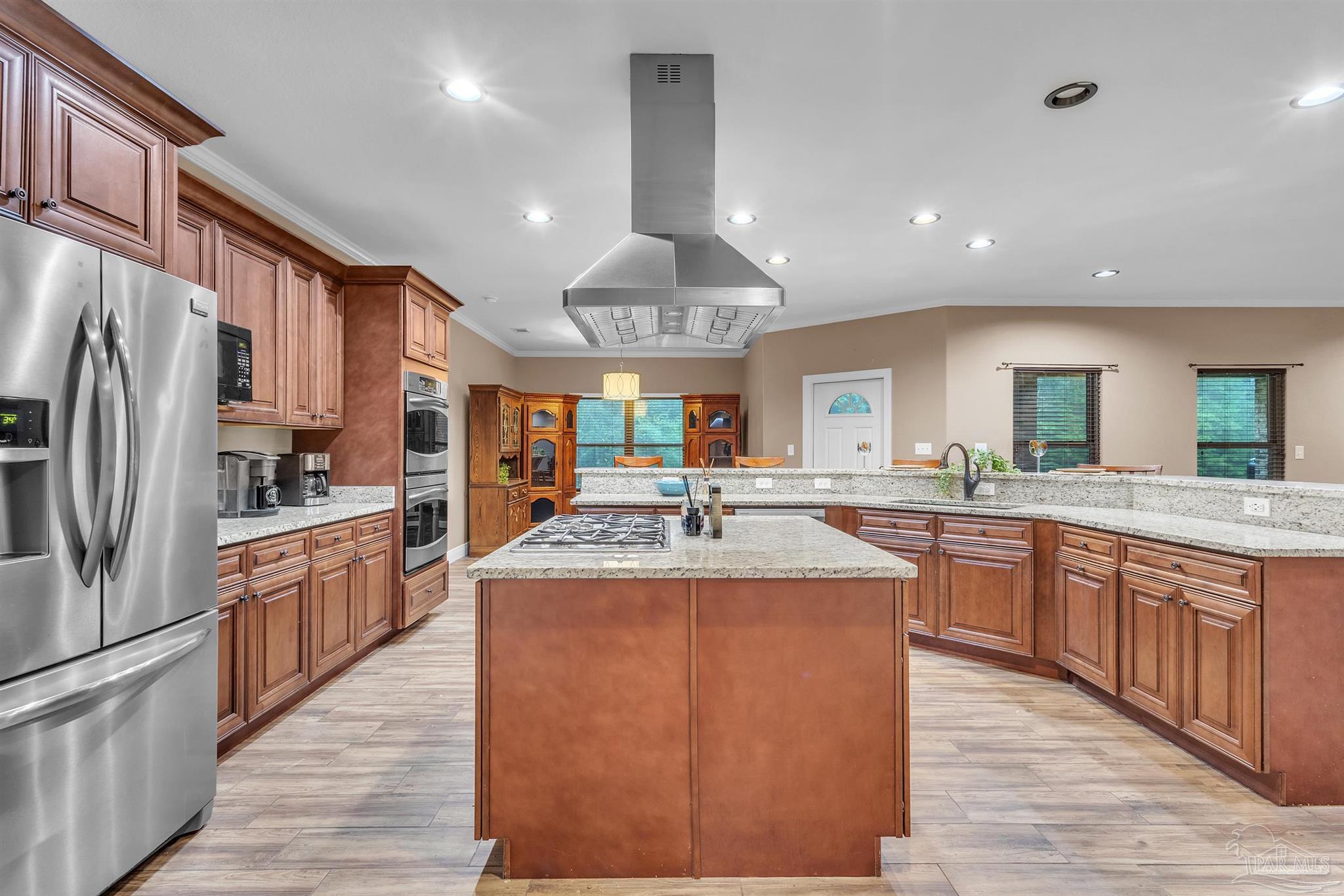 5406 Steele Road Baker, FL 32531 - Photo 12 of 46 a large kitchen with stainless steel appliances kitchen island granite countertop a large kitchen island a stove and a refrigerator