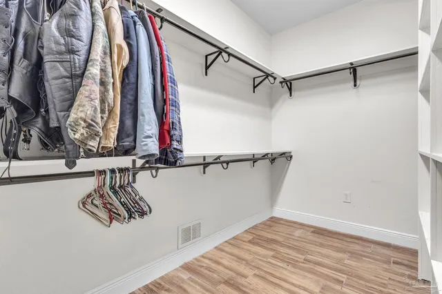 a view of walk in closet with clothes and shoes