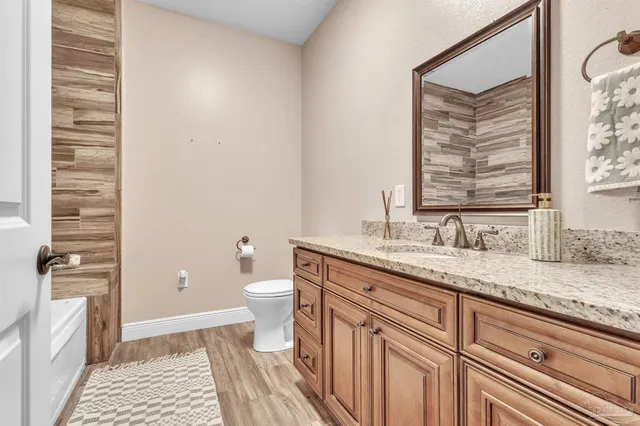 a bathroom with a granite countertop sink toilet and shower