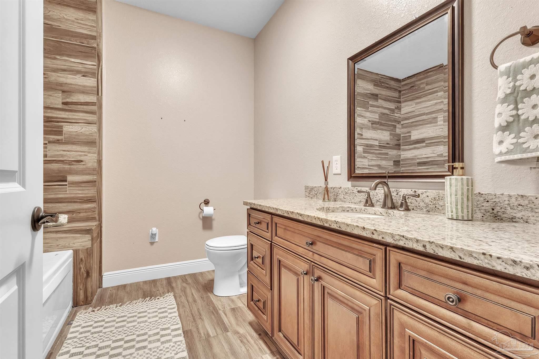 5406 Steele Road Baker, FL 32531 - Photo 28 of 46 a bathroom with a granite countertop sink toilet and shower