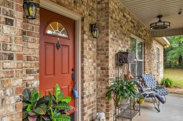 a view of a brick wall with a chair and table in front of a brick building