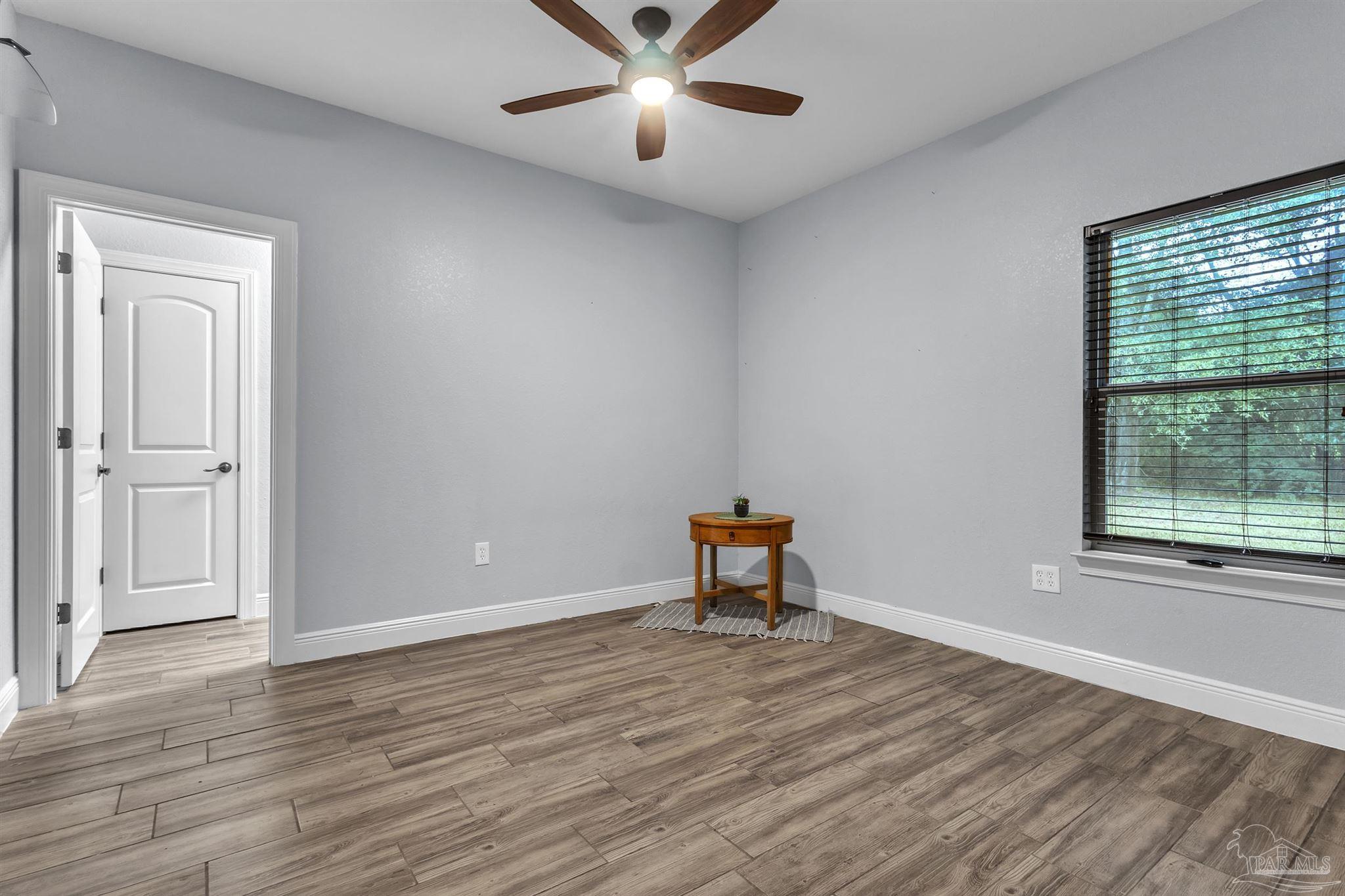 5406 Steele Road Baker, FL 32531 - Photo 31 of 46 a view of an empty room with wooden floor and a window