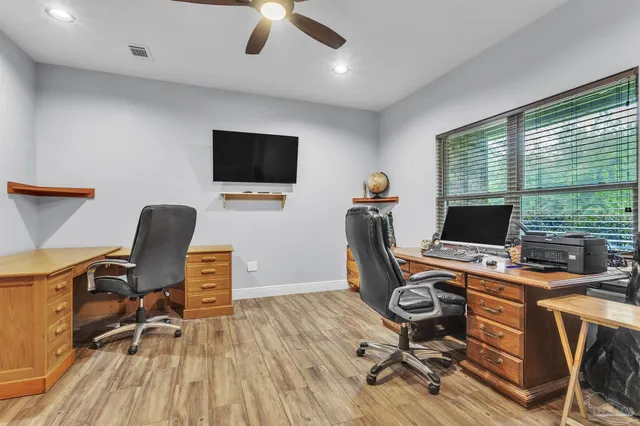 a view of a workspace with furniture and a window